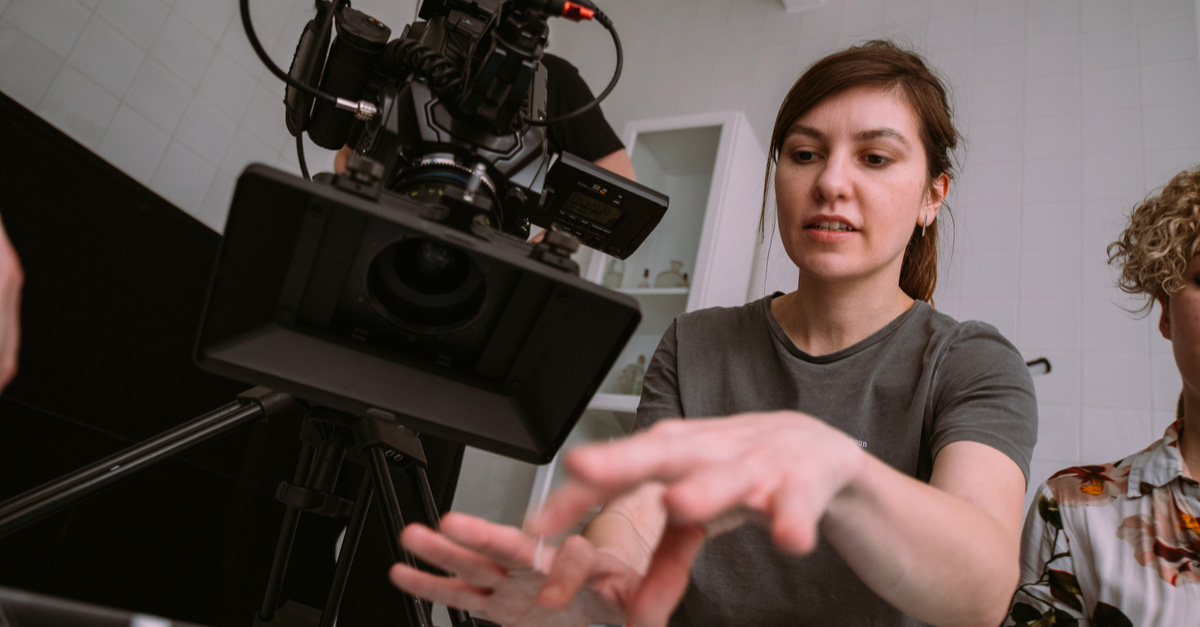 Female Director with camera as part of the film production process on set
