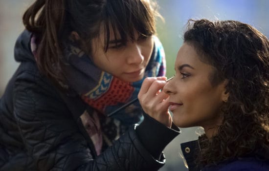 Film makeup artist applying makeup to actress