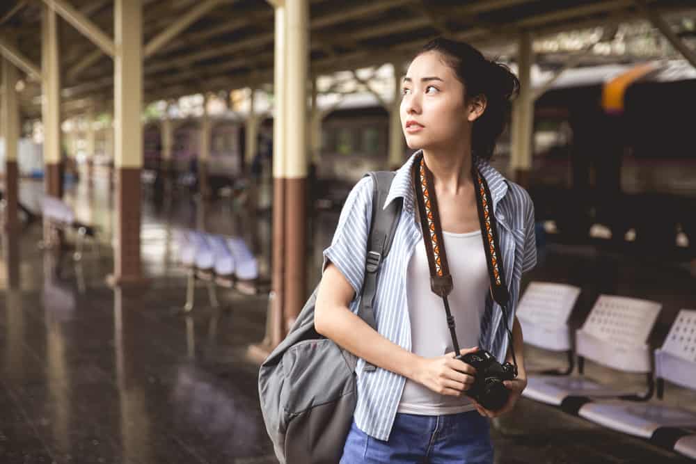 Location scout with camera walking through train station