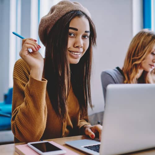 Young female screenwriter writing screenplay on her laptop